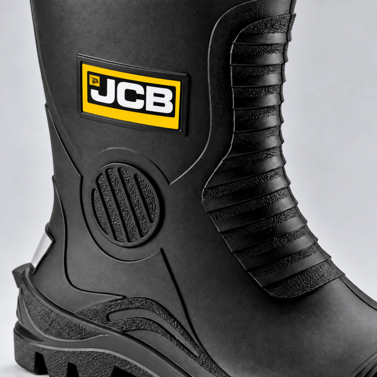 Kalosze ochronne JCB, zbliżenie na żebrowaną cholewkę z żółtym logo i osłoną kostki