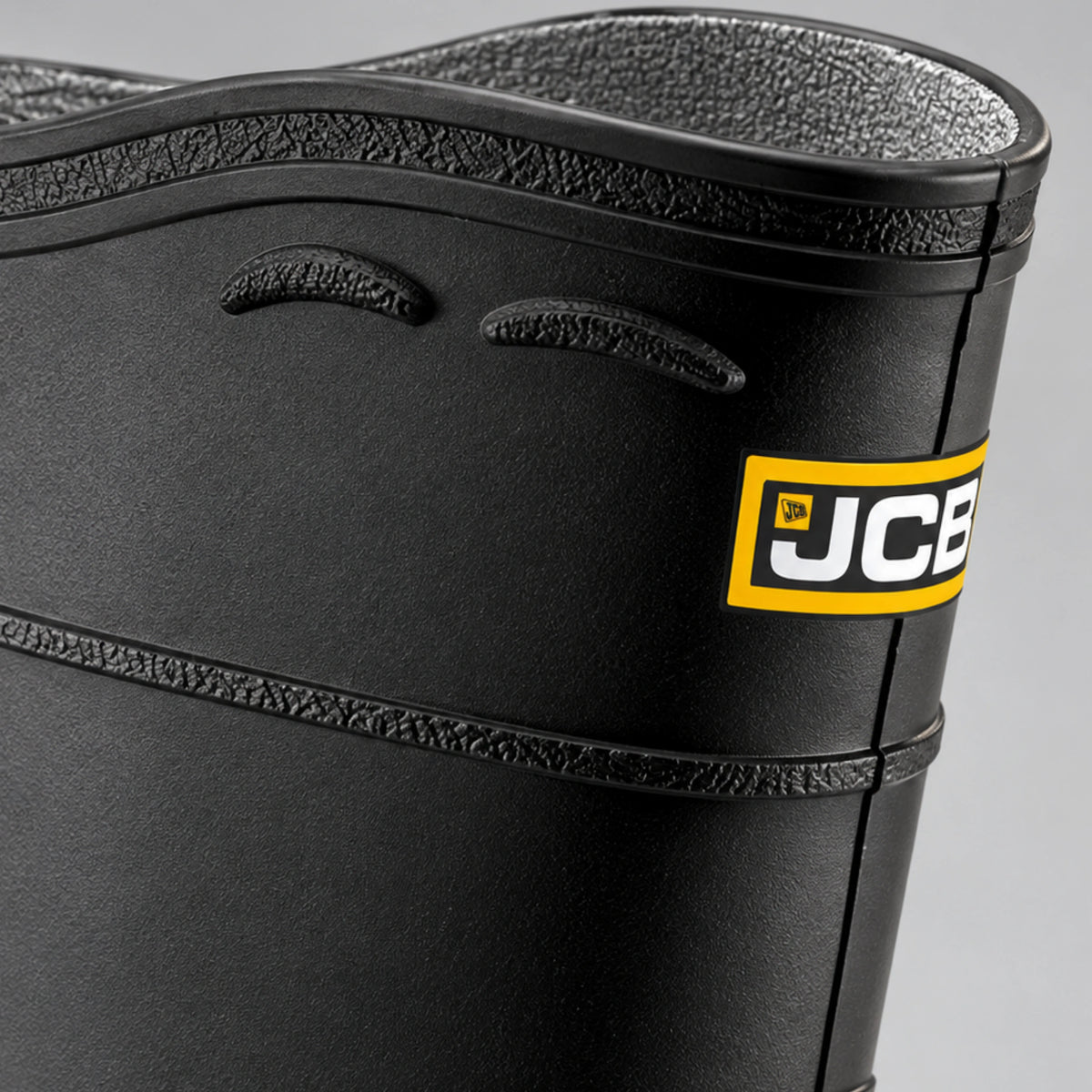 Kalosze robocze JCB, zbliżenie na górną krawędź cholewki z szarą wyściółką i żółtym logo